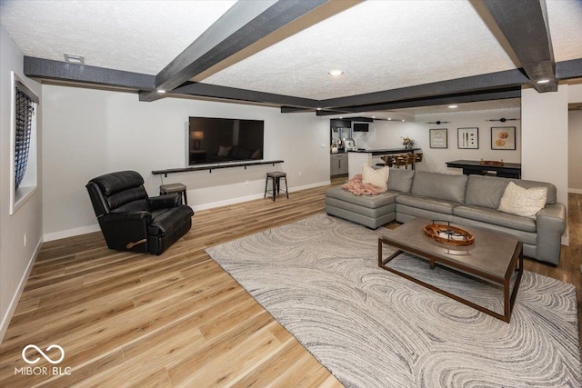 living room featuring a textured ceiling, pool table, hardwood / wood-style flooring, and beamed ceiling