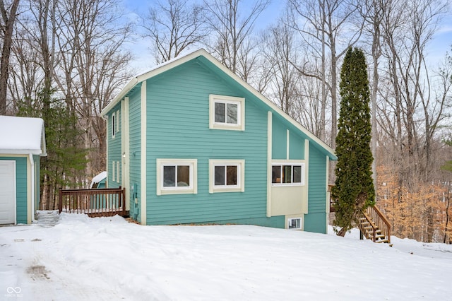 snow covered back of property with a garage