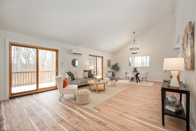 living room featuring a healthy amount of sunlight, a wall mounted AC, light wood-type flooring, and an inviting chandelier