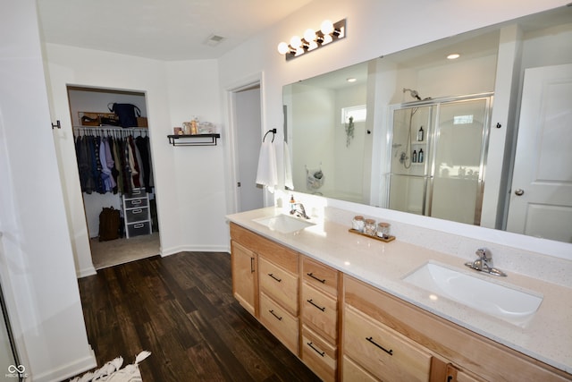 bathroom featuring a shower with door, vanity, and wood-type flooring