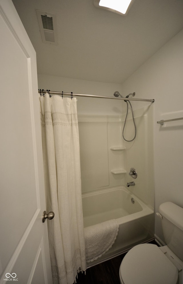 bathroom with shower / bath combination with curtain and toilet