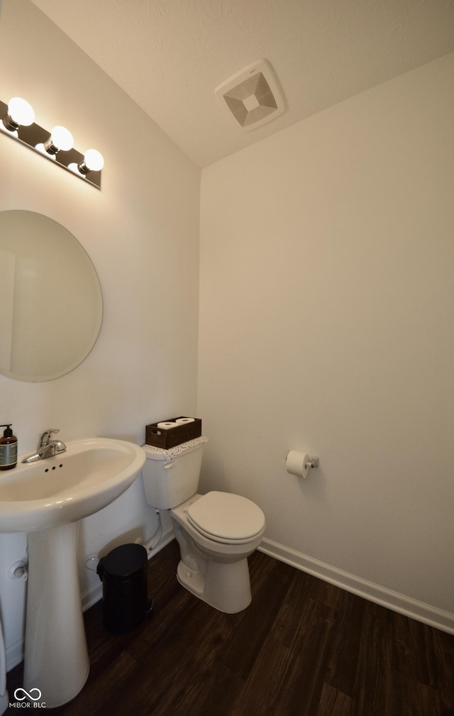 bathroom with sink, toilet, and wood-type flooring