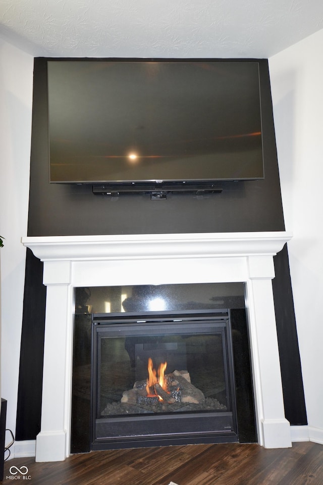 interior details with a large fireplace and hardwood / wood-style flooring