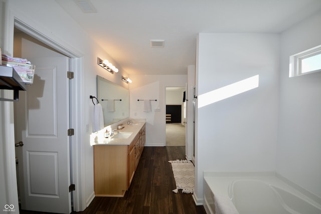 bathroom featuring wood-type flooring, vanity, and a bathtub