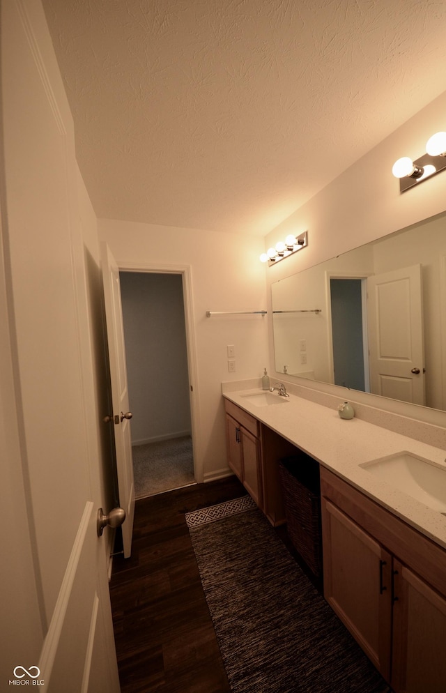 bathroom with hardwood / wood-style flooring, a textured ceiling, and vanity