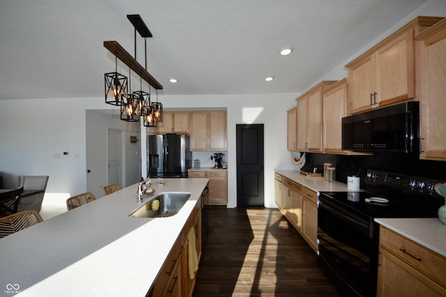 kitchen featuring an inviting chandelier, black appliances, sink, decorative light fixtures, and backsplash