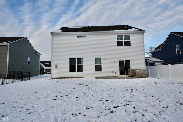 view of snow covered back of property