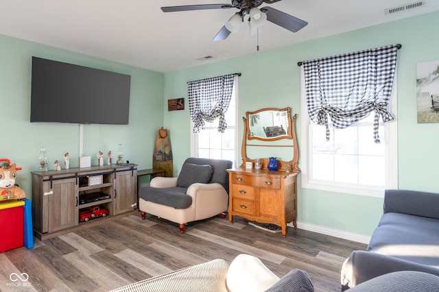 living room featuring ceiling fan and dark wood-type flooring