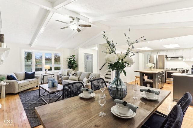 dining space featuring lofted ceiling with beams, ceiling fan, and light hardwood / wood-style floors