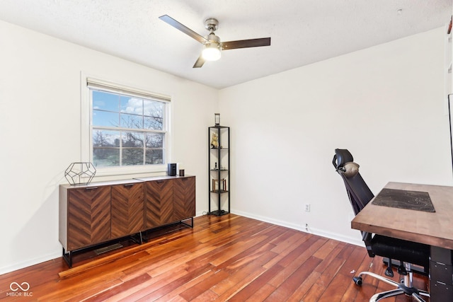 office area with a textured ceiling, wood-type flooring, and ceiling fan