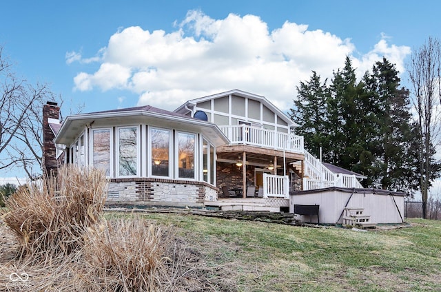 rear view of house featuring a yard and a sunroom