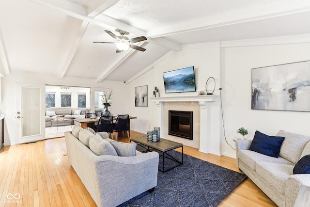 living room with hardwood / wood-style floors, a fireplace, vaulted ceiling with beams, and ceiling fan