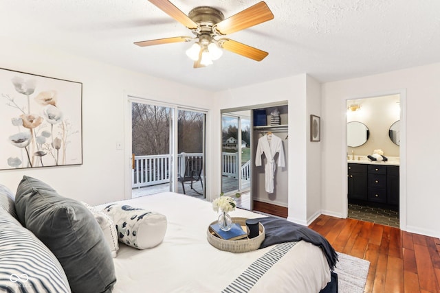 bedroom with dark wood-type flooring, connected bathroom, a textured ceiling, access to outside, and a closet