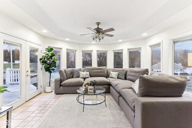 living room featuring french doors, light tile patterned floors, ceiling fan, and a tray ceiling