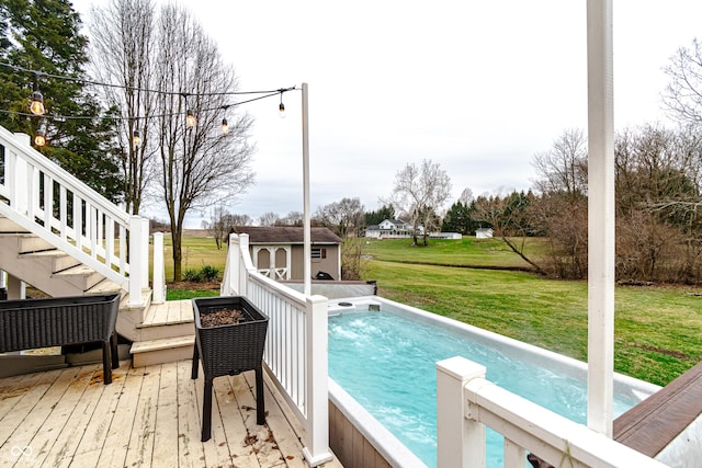 view of swimming pool featuring a storage shed, a lawn, and a wooden deck