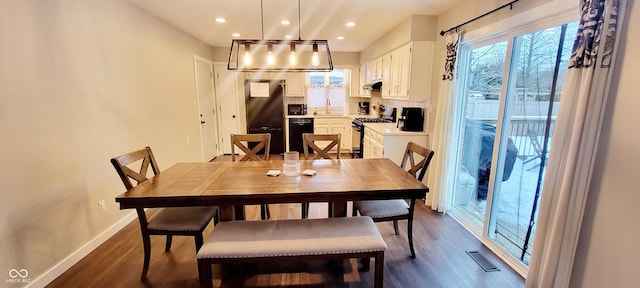 dining room featuring sink and dark hardwood / wood-style flooring