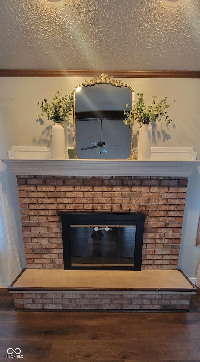 details featuring a textured ceiling, crown molding, a fireplace, and hardwood / wood-style flooring