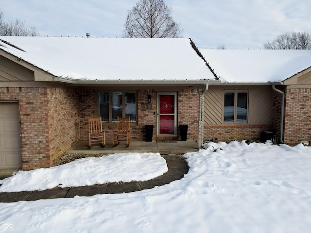 ranch-style house featuring a garage and covered porch