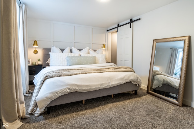 carpeted bedroom featuring a barn door