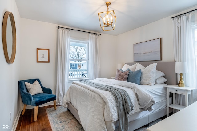 bedroom featuring an inviting chandelier and hardwood / wood-style floors