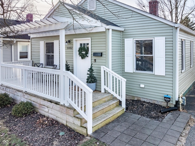 property entrance with a pergola