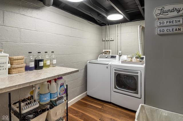 washroom with dark hardwood / wood-style flooring and washing machine and dryer