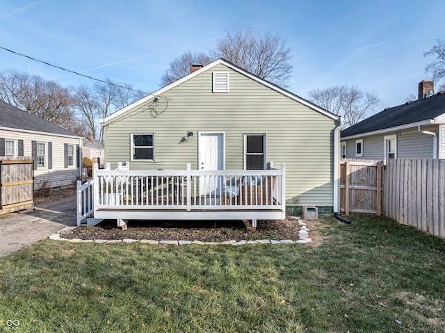 rear view of property featuring a yard and a wooden deck