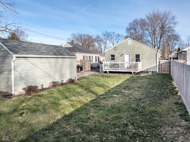 rear view of property featuring a deck and a lawn