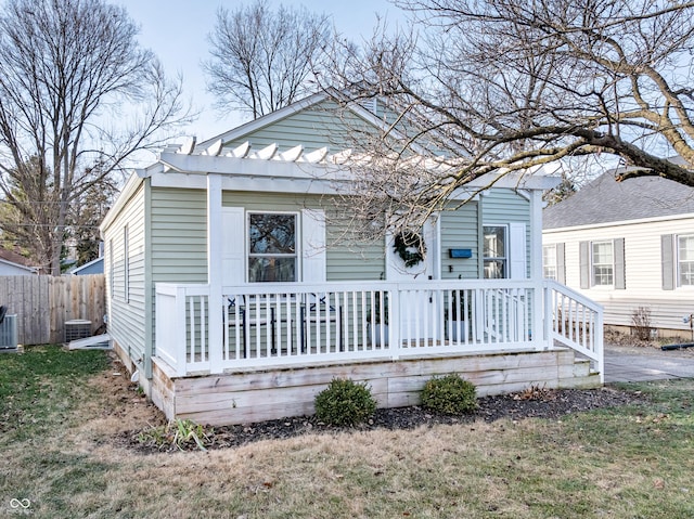 bungalow-style house featuring central air condition unit and a front yard