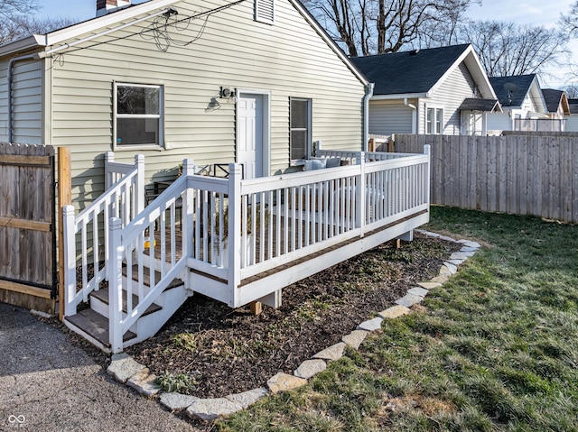 rear view of property featuring a deck and a lawn