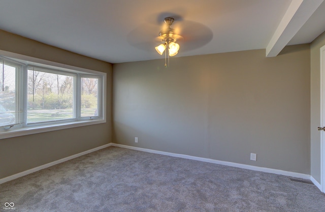 carpeted empty room with a ceiling fan and baseboards