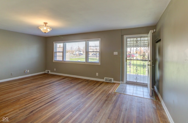 entrance foyer featuring wood finished floors, visible vents, and baseboards