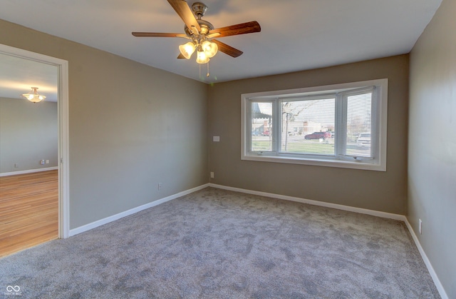 carpeted empty room featuring ceiling fan and baseboards