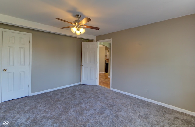 unfurnished bedroom featuring baseboards, arched walkways, ceiling fan, and carpet flooring