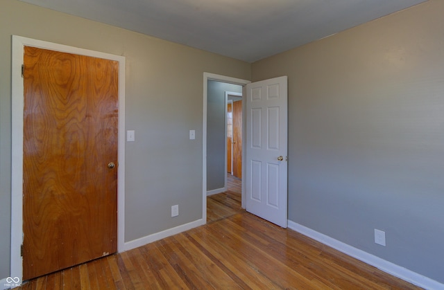 unfurnished bedroom with wood finished floors and baseboards