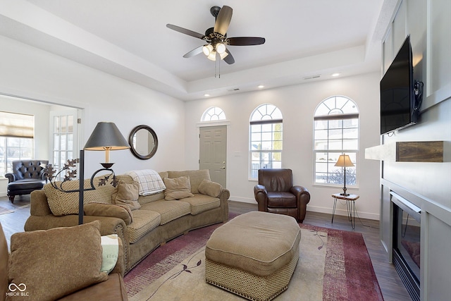 living room featuring visible vents, wood finished floors, a glass covered fireplace, recessed lighting, and baseboards