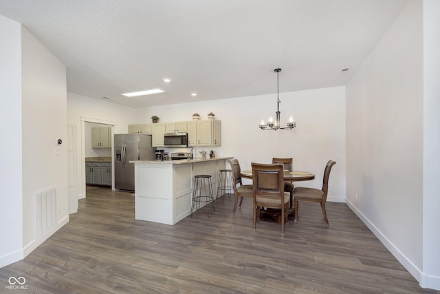 dining space with dark wood-style floors, visible vents, a notable chandelier, and baseboards