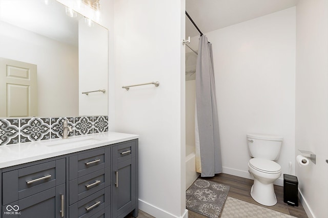 bathroom with vanity, wood finished floors, baseboards, toilet, and shower / tub combo with curtain