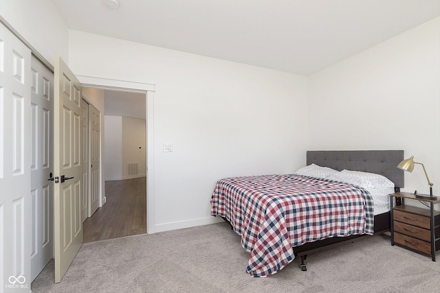 bedroom featuring a closet, visible vents, baseboards, and carpet floors