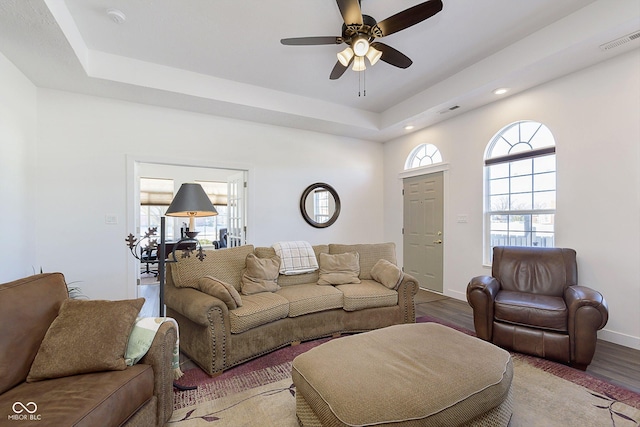 living area with visible vents, plenty of natural light, and wood finished floors