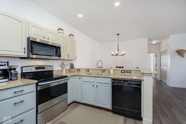 kitchen featuring a peninsula, dark wood-style floors, appliances with stainless steel finishes, and a sink