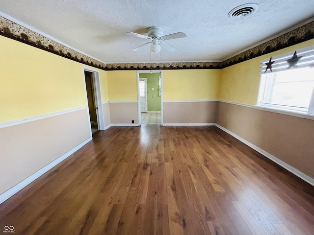 empty room featuring hardwood / wood-style flooring, a textured ceiling, and ceiling fan