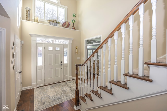 entrance foyer featuring a high ceiling, a wealth of natural light, and dark wood-type flooring