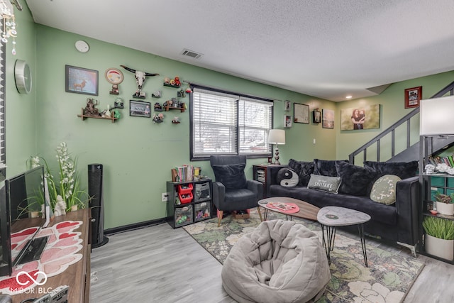 living room featuring a textured ceiling and light hardwood / wood-style flooring