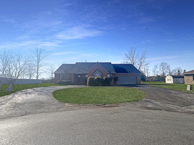 view of front of home with an attached garage, aphalt driveway, and a front yard