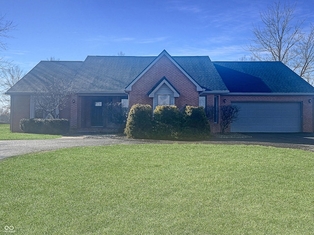 view of front of home featuring aphalt driveway, roof with shingles, an attached garage, and a front lawn