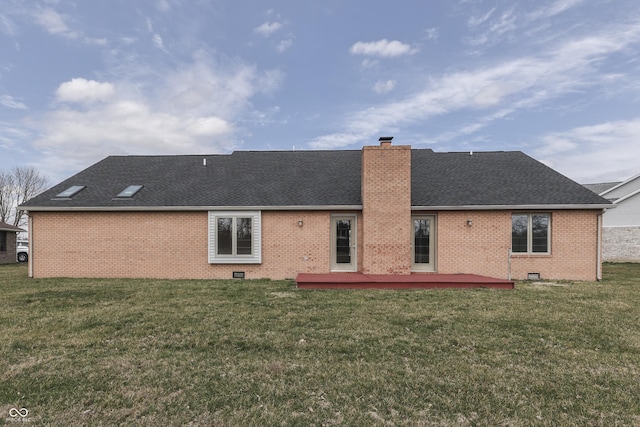 back of house with a chimney, a lawn, brick siding, and a shingled roof