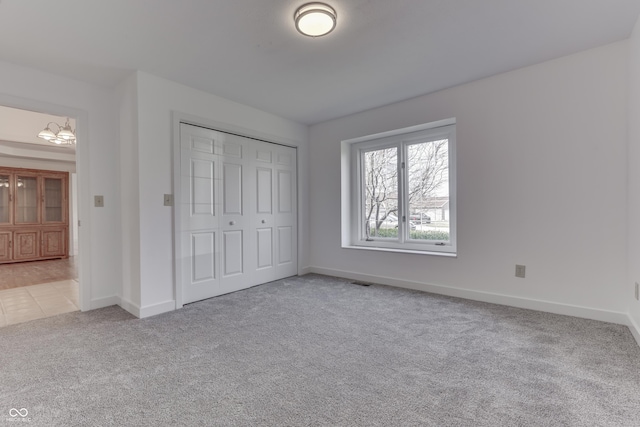 unfurnished bedroom featuring a closet, visible vents, baseboards, and carpet floors