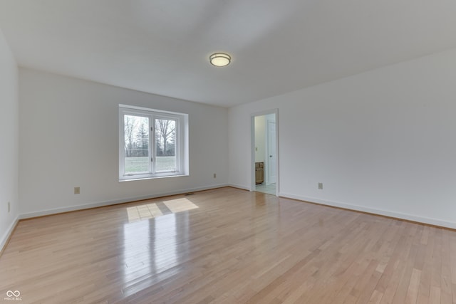 empty room with baseboards and light wood-style floors