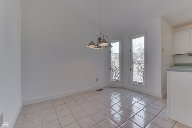 unfurnished dining area with light tile patterned flooring, a notable chandelier, visible vents, and baseboards